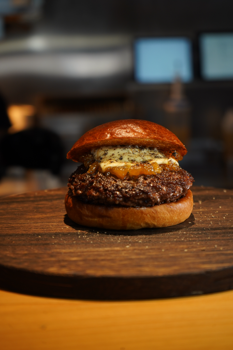The Hanaga Akaushi burger held in gloved hands