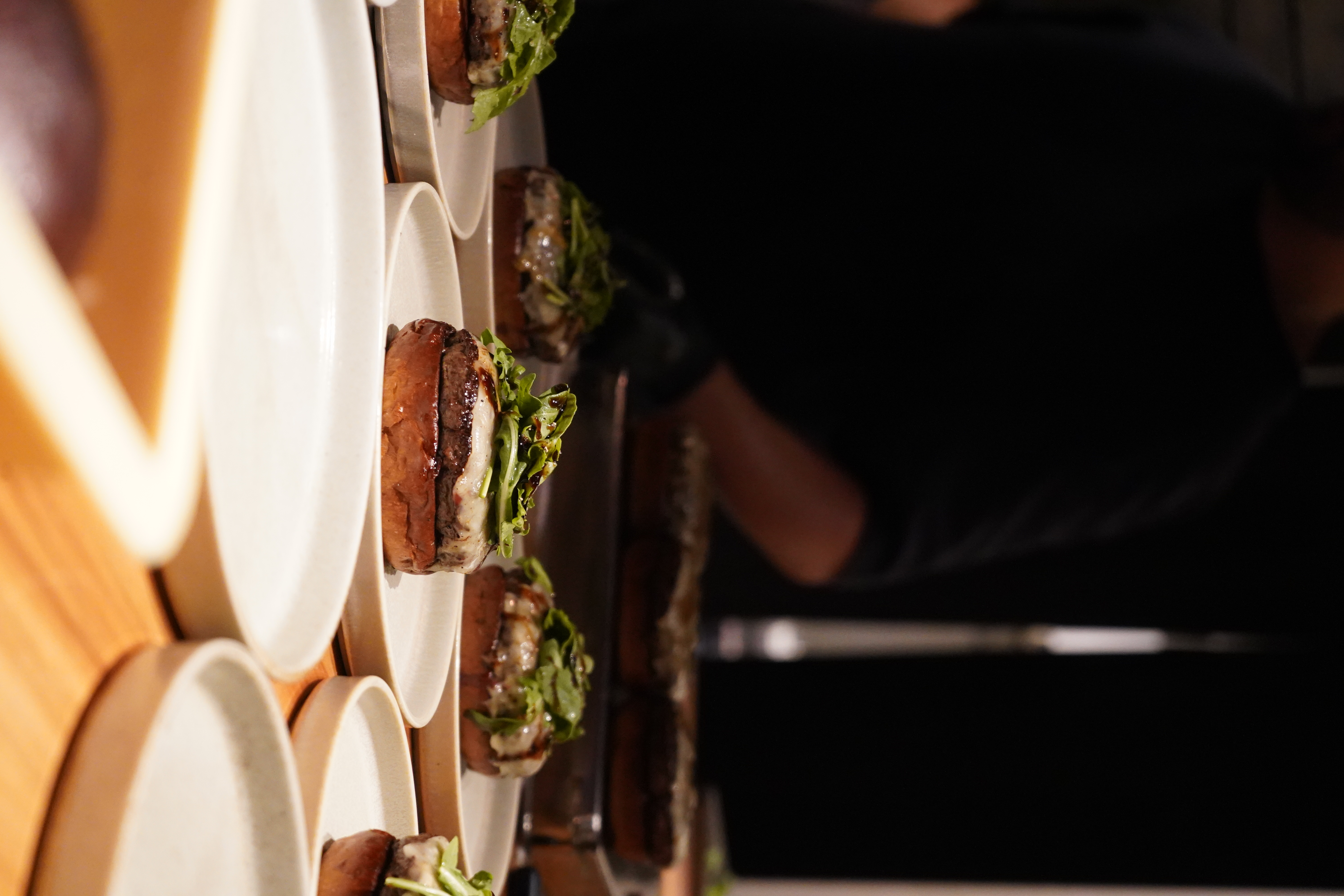 A row of the limited Wagyu burgers plated on the pass at Kitan Hibiki