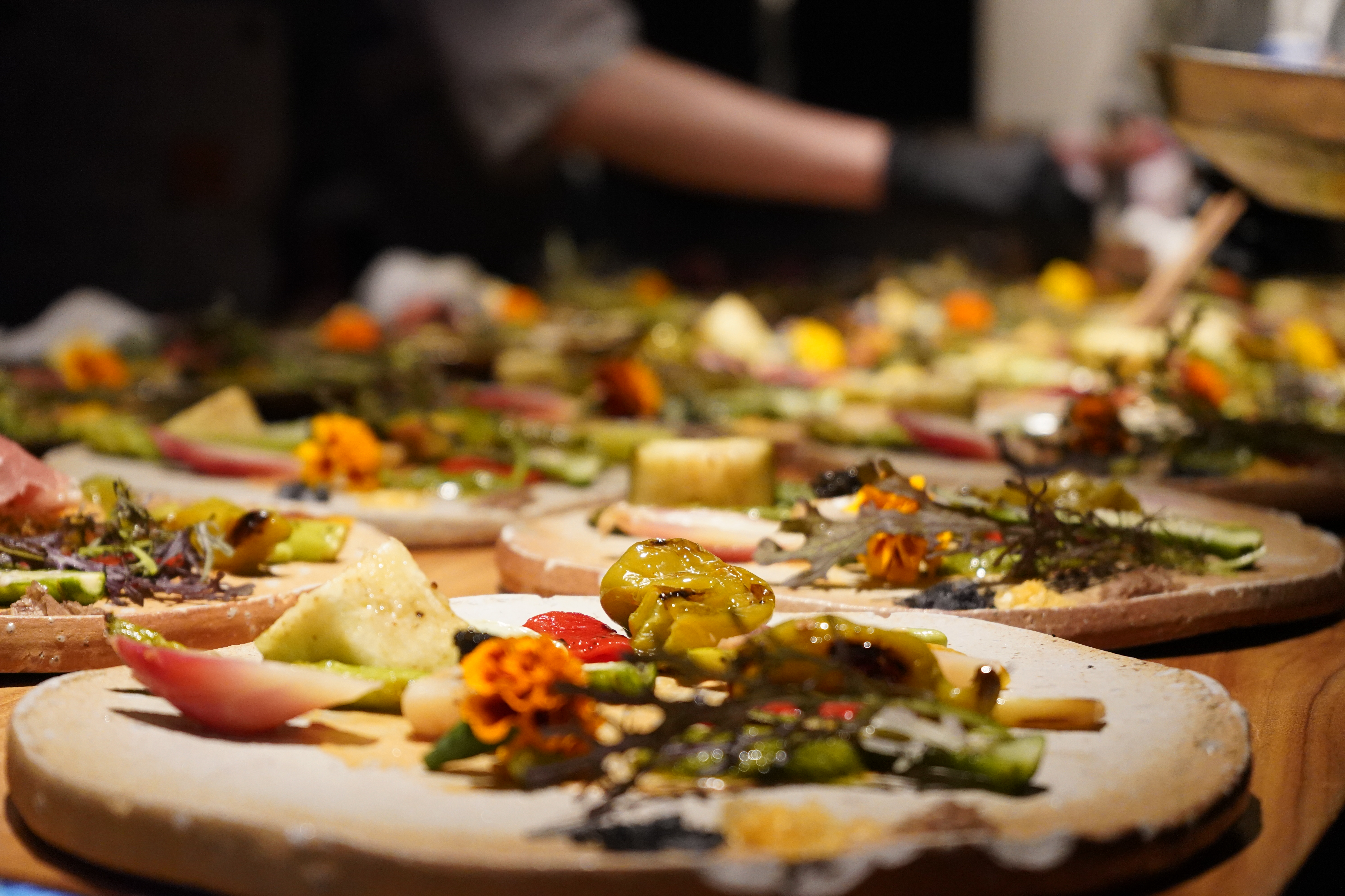 A row of antipasti boards garnished with marigold and grilled vegetables